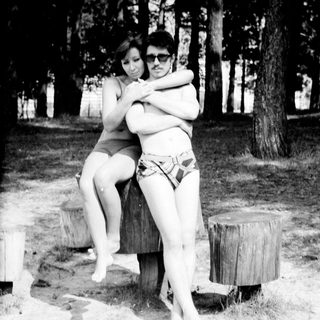 Two people hugging outdoors in swimwear.