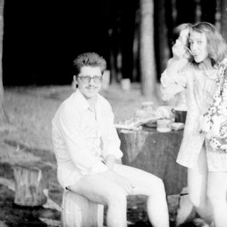 Three people posing outdoors at night, 1950s-60s style.