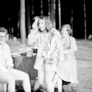 Three people posing outdoors at night, 1950s-60s style.