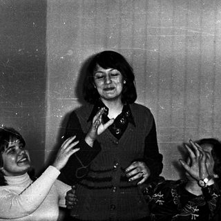 Group laughing during indoor gathering or performance.