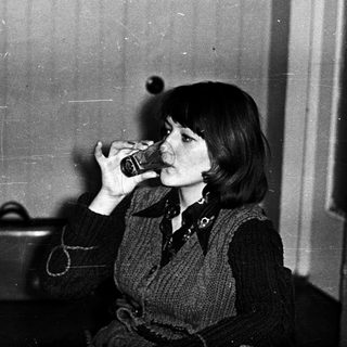 Woman drinking from a glass indoors.