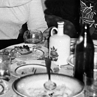 Two women laughing together at a dinner table.