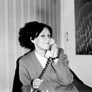Woman speaking on a vintage rotary phone.