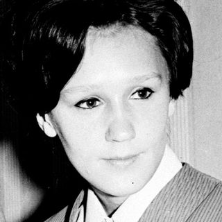 Two women in 1960s-style suits, black-and-white portrait.