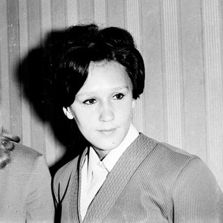 Two women in 1960s-style suits, black-and-white portrait.