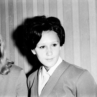 Two women in 1960s-style suits, black-and-white portrait.