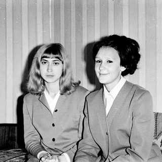 Two women posing together in formal attire, black-and-white.