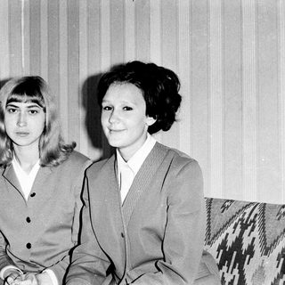 Two women posing together in formal attire, black-and-white.