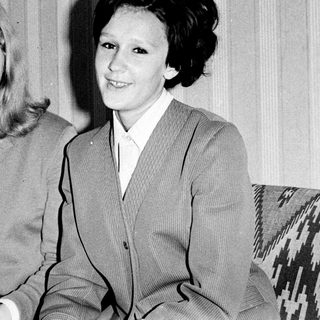 Two women posing together indoors, mid-20th century.