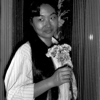 Person in traditional attire holding flowers.