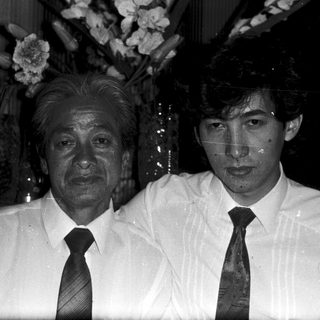 Two men posing indoors, one older, one younger.