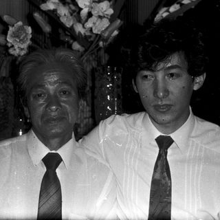 Two men in formal attire posing indoors.