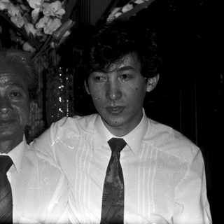 Two men in formal attire posing indoors.