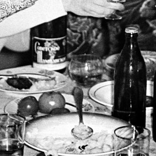 Group of people toasting indoors with wine.