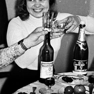 Three women celebrating with champagne toast indoors.