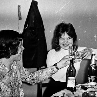 Three women celebrating with champagne toast indoors.