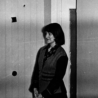 Woman standing indoors near doorway.