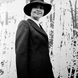 Elegant woman in 1950s-style suit and hat.