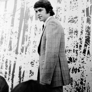 Young man in 1970s-style suit indoors.