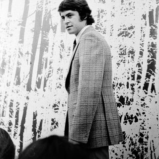 Young man in 1970s-style suit indoors.
