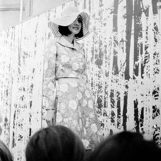 Elegant woman in floral dress poses indoors.