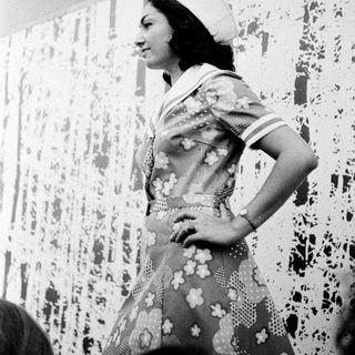 Woman in vintage nurse uniform with floral dress.