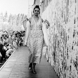 Fashion show model walking down runway.