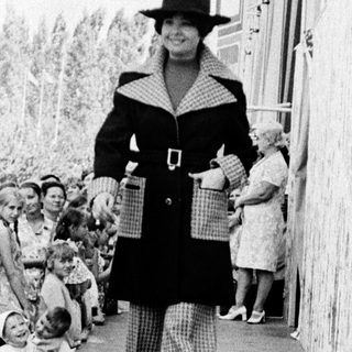 Fashion show model walking down runway.