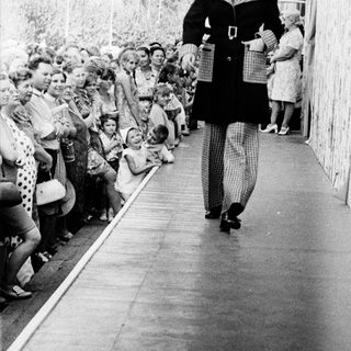 Fashion show model walking down runway.