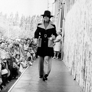 Fashion show model walking down runway.