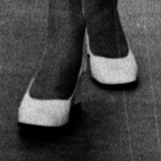 Fashion model walking on runway with audience.