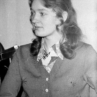 Young woman with shoulder-length hair in a vintage sweater.