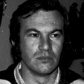 Black-and-white portrait of a man in a sweater.