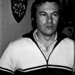 Black-and-white portrait of a man in a sweater.