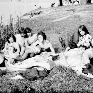 Group of people relaxing outdoors by water.