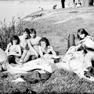 Group enjoying picnic by lake.