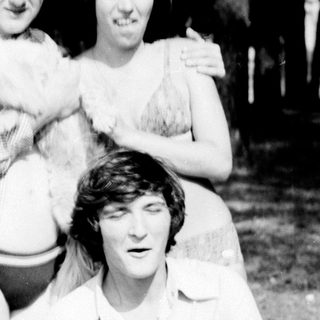 Three people posing outdoors in casual summer attire.