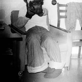 Child sitting at desk holding small dog.