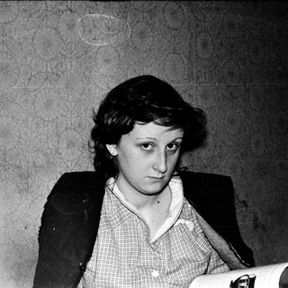 Woman reading documents in formal attire.