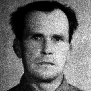 Portrait of a man in a formal, dark shirt.