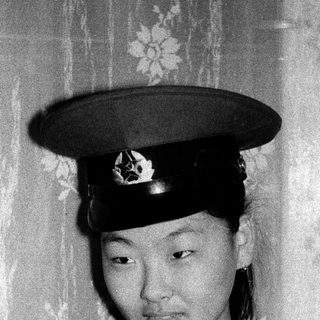 Young woman in traditional military-style hat.