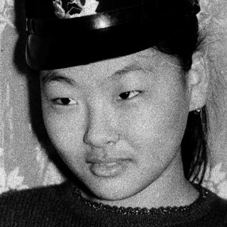 Young woman in traditional military-style hat.