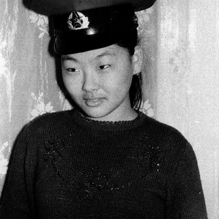 Young woman in traditional military-style hat.