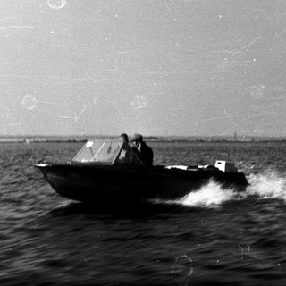 Small boat moving swiftly on rough sea.
