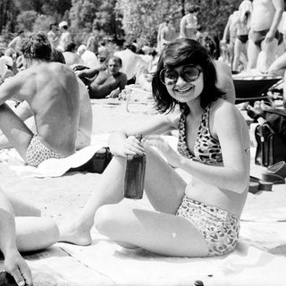 People relaxing and socializing outdoors by a lake.