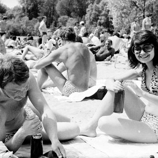 People relaxing and socializing outdoors by a lake.