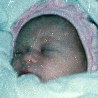 Newborn baby wrapped snugly in a blanket.