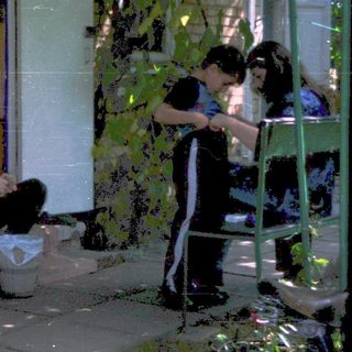 People washing dishes outdoors in backyard.