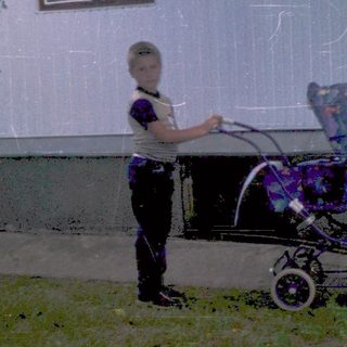A person pushing a stroller in an outdoor area.
