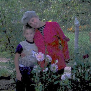 A woman and child standing among garden flowers.
